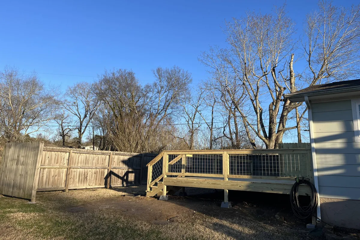 A serene wooden deck with outdoor furniture, fence, and views of bare trees, evoking moments of relaxation and togetherness just outside the kitchen. The deck’s ambiance invites after-dinner chats while enjoying sunset views or morning coffee in the fresh air.